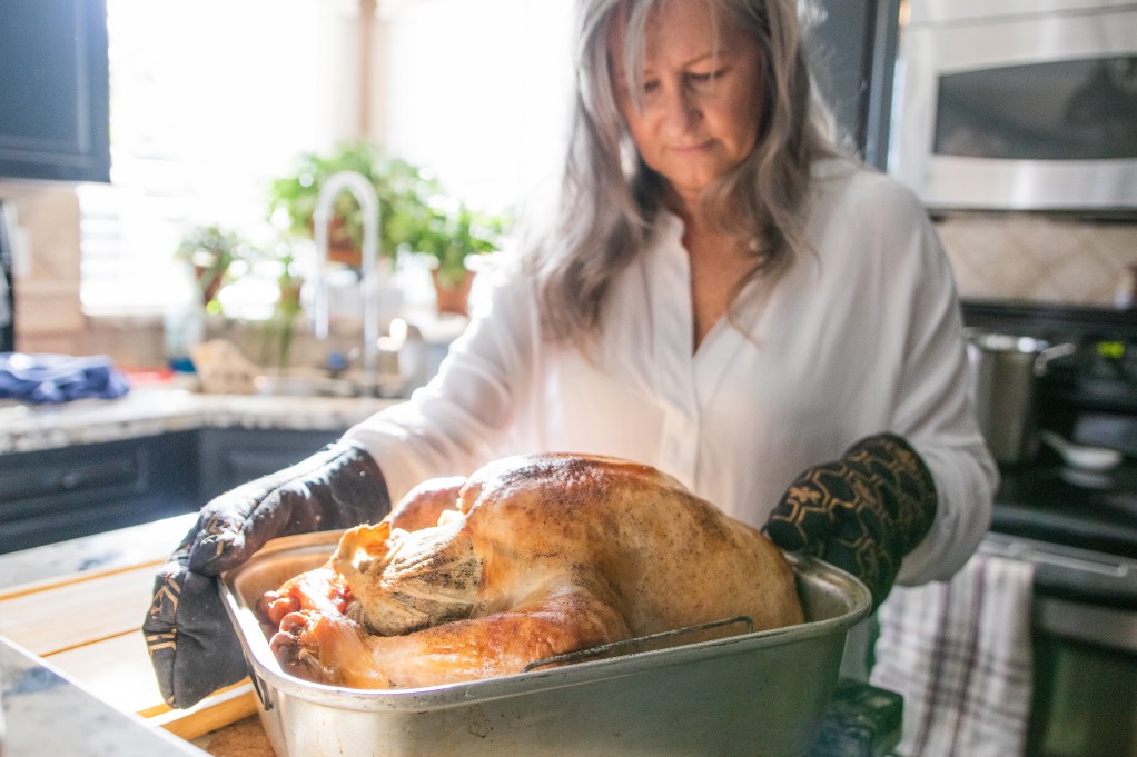 mature-woman-taking-thanksgiving-turkey-out-of-the-oven_t20_B8063Y